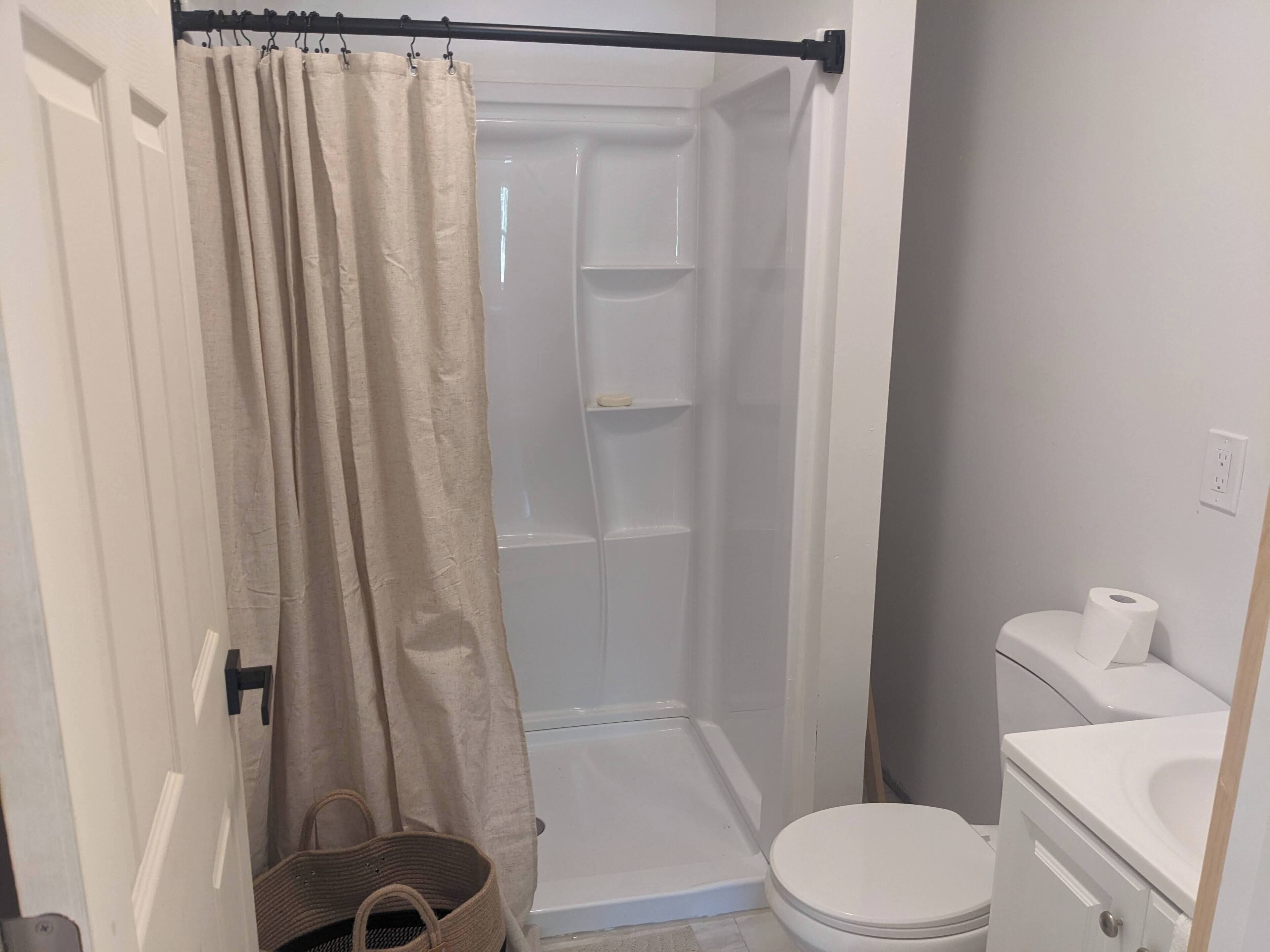 Ein kleines Badezimmer mit Dusche, Toilette und Waschbecken.