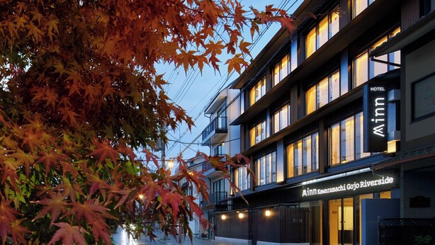 Ett modernt hotell med en skylt som visar texten: ”Minn Kawaramachi Gojo Riverside”.