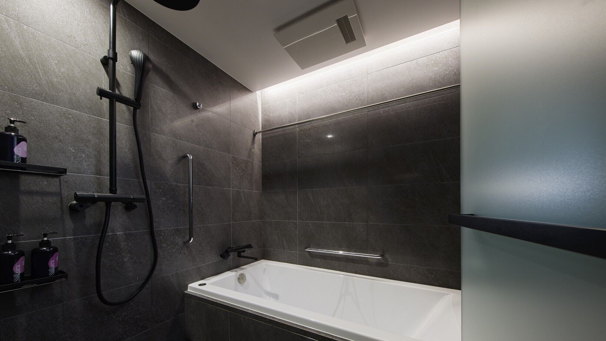 A modern bathroom with a bathtub, a shower with a handheld showerhead, and a glass-enclosed shower stall.
