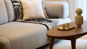 Una sala de estar con un sofá, una mesa de centro y una lámpara.