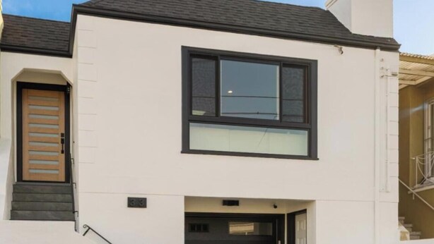 Een modern huis met twee verdiepingen, een voordeur, een garage en een trap naar de ingang.