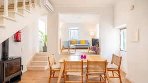 Una sala de estar moderna con comedor, una escalera y una chimenea.