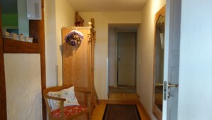 A hallway with a wooden door, a chair with a floral cushion, and a brown rug. - Holiday Home 'Waren An Der Müritz' with Lake View, Private Terrace and Wi-Fi (Waren (Müritz))