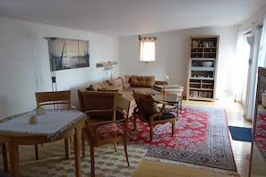 A living room with a sofa, chairs, a table, a bookshelf, and a painting on the wall. - Holiday Home 'Waren An Der Müritz' with Lake View, Private Terrace and Wi-Fi (Waren (Müritz))