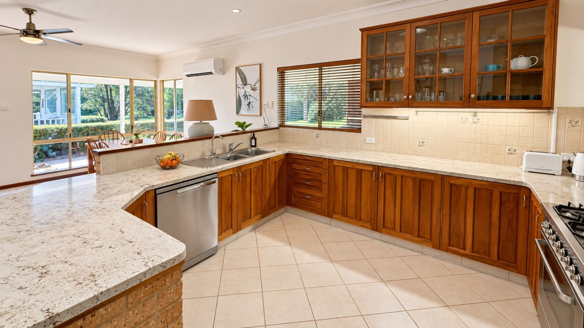 A modern kitchen with wooden cabinets, a built-in dishwasher, and a large window providing natural light.