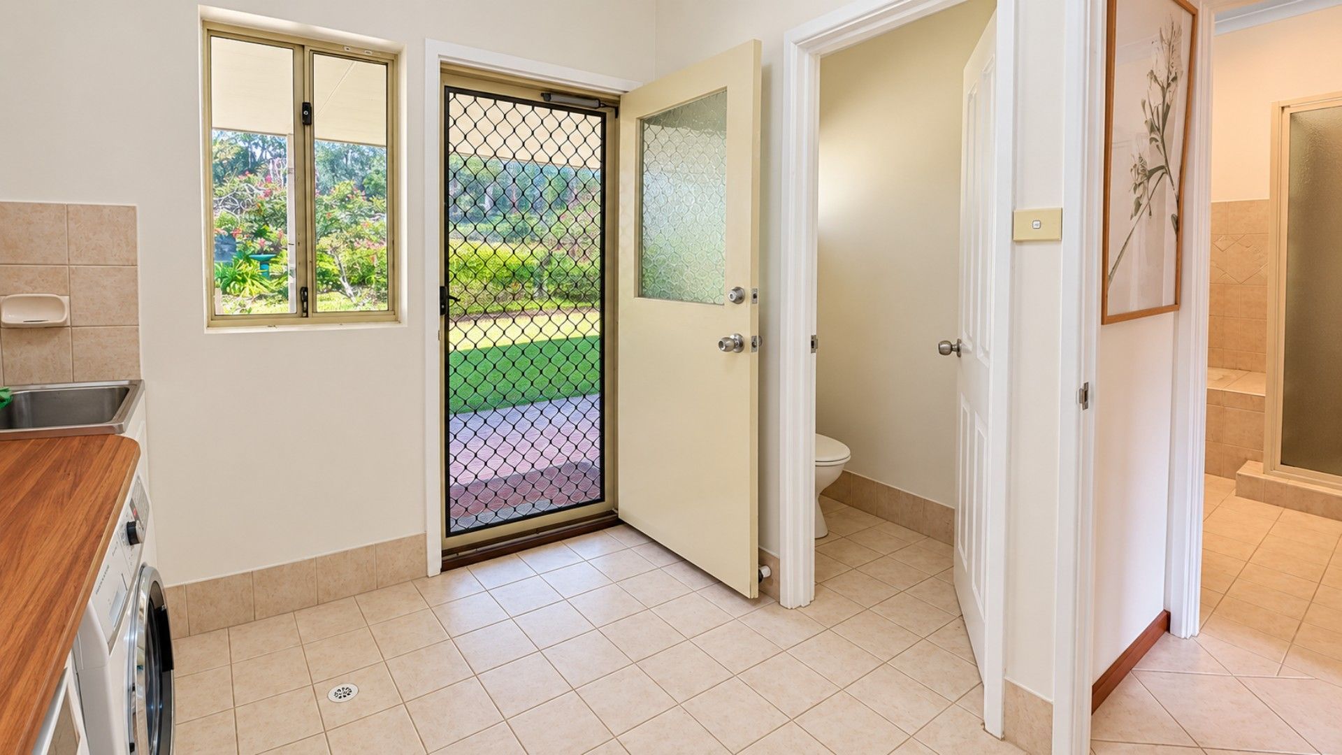 A bathroom with a toilet, a shower area, and a sink.