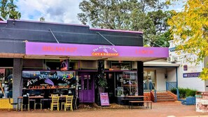A cafe and bakery with outdoor seating, a purple awning, and a sign indicating it serves breakfast and lunch. - Chalwell Lodge – your luxurious rural retreat nestled in the heart of Carlotta. (Nannup)