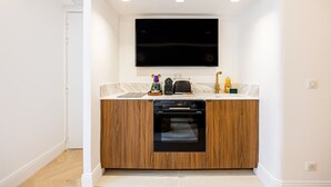 A compact kitchen with a built-in oven, a microwave, and a sink.