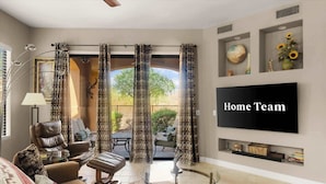 A living room with a sofa, armchairs, a coffee table, and a TV mounted on the wall. - Shared Poolside Fun~Hot Tub~Gym & More (Phoenix)