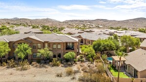 A residential area with multiple houses, each featuring a similar architectural style with tiled roofs and stone facades. - Shared Poolside Fun~Hot Tub~Gym & More (Phoenix)