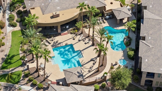 An aerial view of a resort with two swimming pools, palm trees, and lounge areas. - Shared Poolside Fun~Hot Tub~Gym & More (Phoenix)