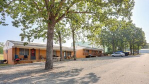 Ein Motel mit Kiesweg, Picknicktischen und einem geparkten Auto vor der Fassade.