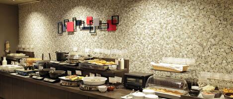 A buffet area with various food items and a microwave.
