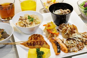 Una variedad de platos que incluyen arroz, verduras y carne, servidos en un plato blanco.