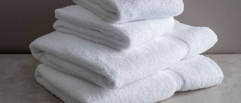 Une pile de serviettes blanches sur une surface en marbre.