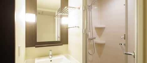 Un baño con lavamanos, espejo y ducha.