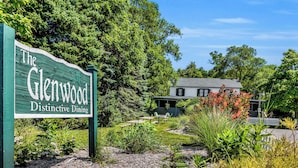 A green sign for 'The Glenwood Distinctive Dining' with a house and outdoor seating area in the background.