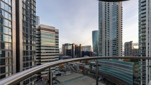 Un immeuble de grande hauteur doté d’une architecture moderne, caractérisé par une façade en verre remarquable et un garde-corps de balcon en métal.