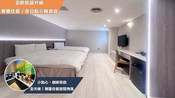 A modern hotel room with a large bed, a desk, and a TV. There is a small kitchenette area with a fridge and a microwave.