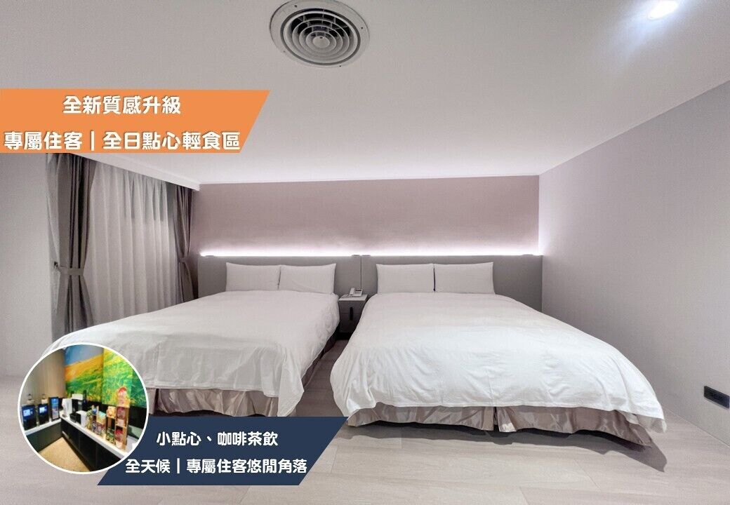 Une chambre d’hôtel moderne avec deux lits, une grande fenêtre et un ventilateur de plafond.