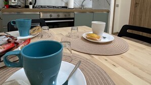 Une cuisine moderne avec des armoires grises, une hotte de cuisinière en acier inoxydable et un dosseret en marbre.