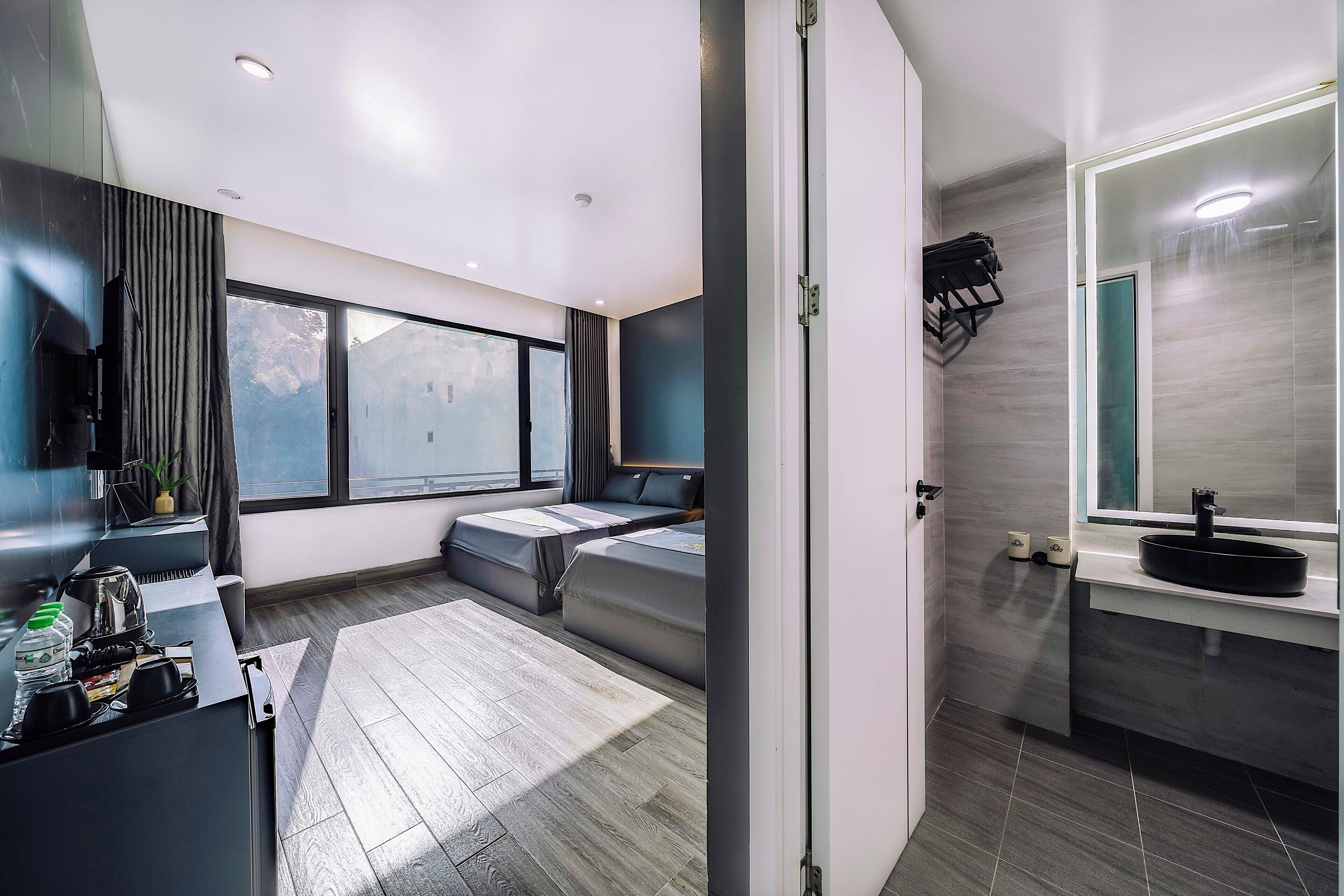 A modern bathroom with a large mirror, a sink, and a shower area.