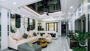 A modern living room with a sofa, ottoman, and a round coffee table. - Cat Ba Nam Phong Hotel (Hai Phong)