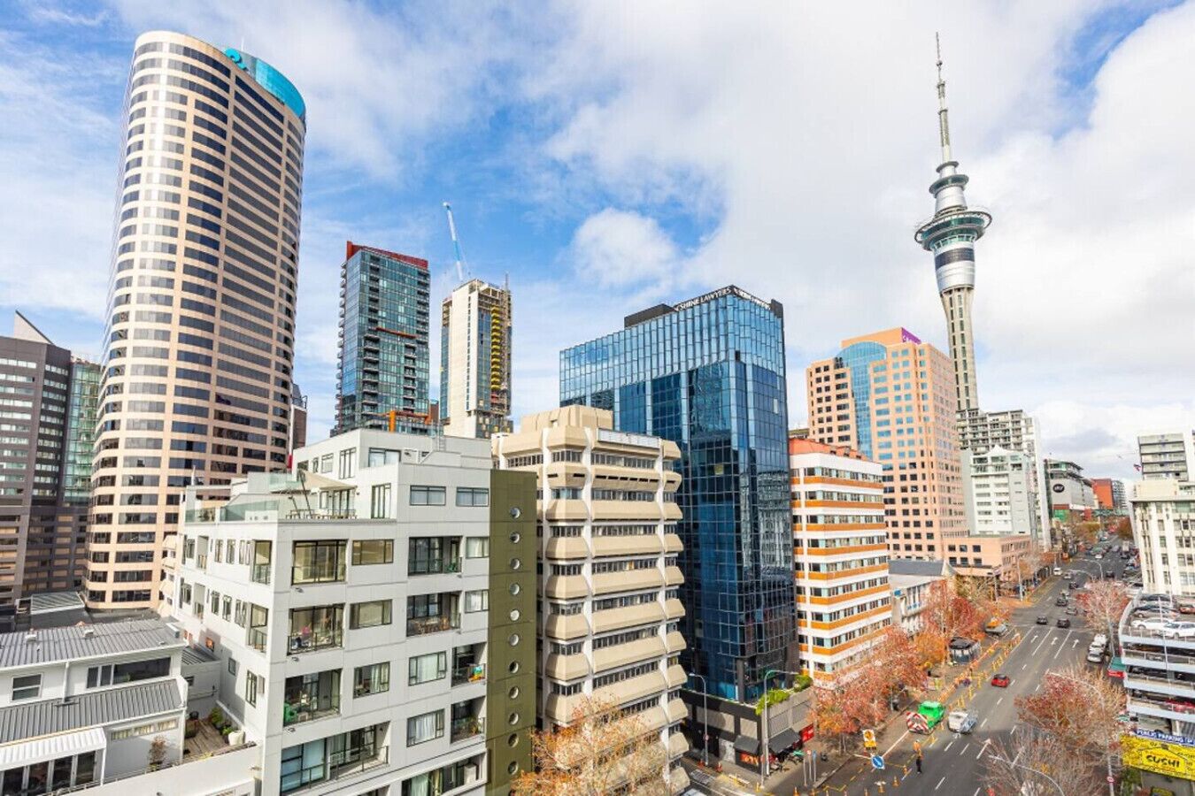 A cityscape with modern high-rise buildings, including a distinctive tower with a spire.