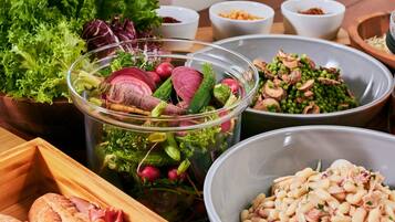 A variety of food items including a salad, beans, and vegetables.