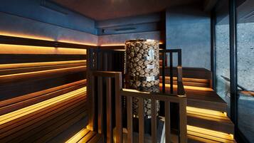 Una sauna moderna con bancos de madera y un calentador cilíndrico central.