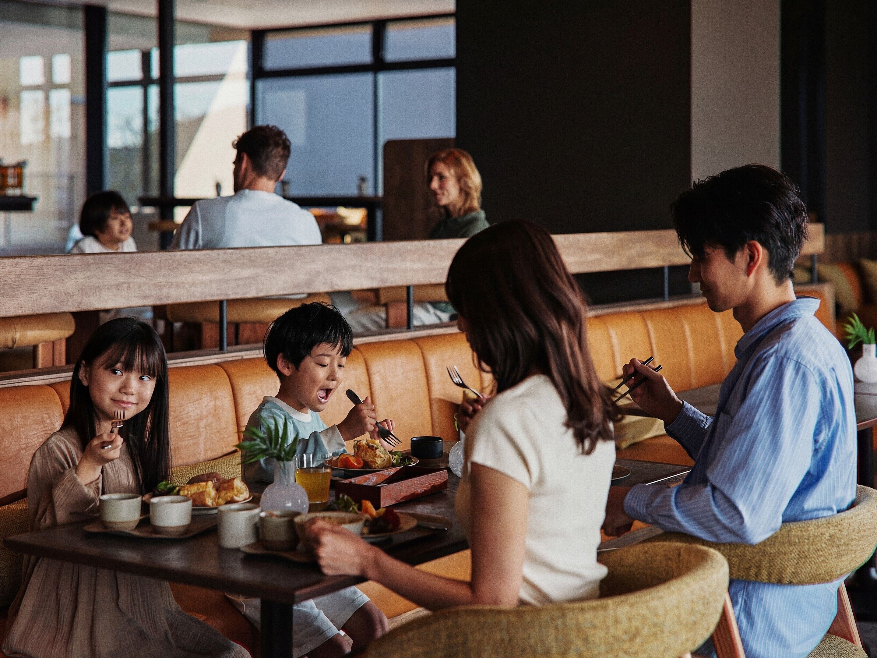 A restaurant with wooden benches and tables, where people are dining.