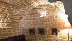 Una habitación con paredes de piedra, un sofá de cuero y una mesa de madera.