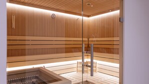 A sauna with wooden benches and a glass partition. - Apartment fur bis zu 4 Personen (Kaprun)