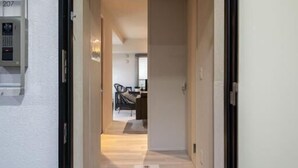 A hotel entrance with a carpeted hallway leading to a dining area. - Mondomio Sapporo 207 (Sapporo)