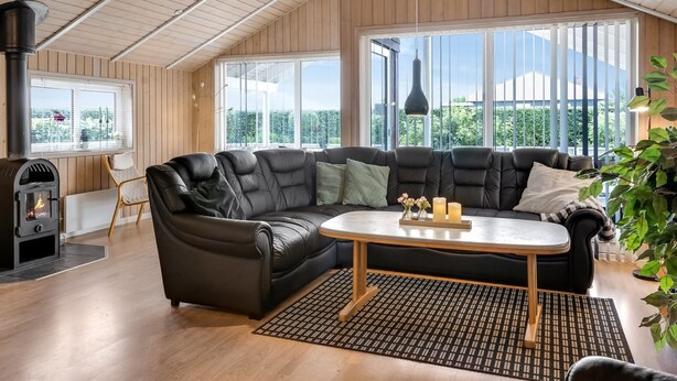 A spacious living room with a large sectional sofa, a small round table, and a fireplace.