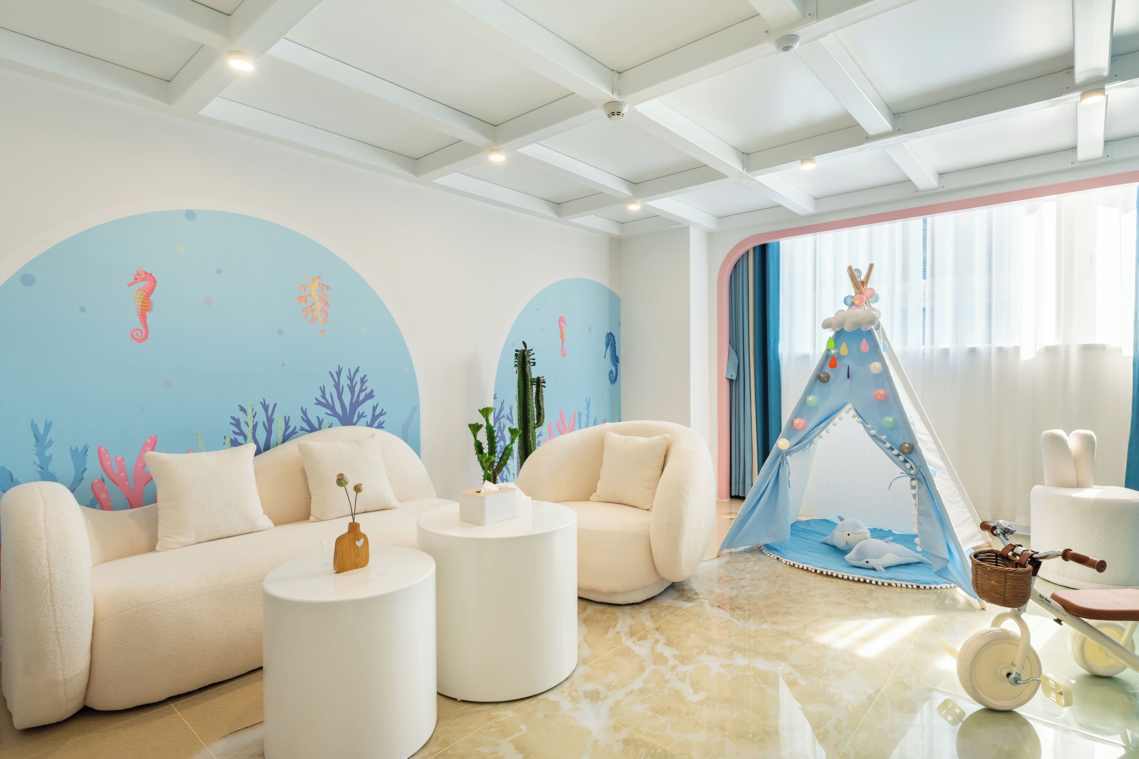 Een moderne woonkamer met een bank, twee bijzettafels, een tent en een driewieler.