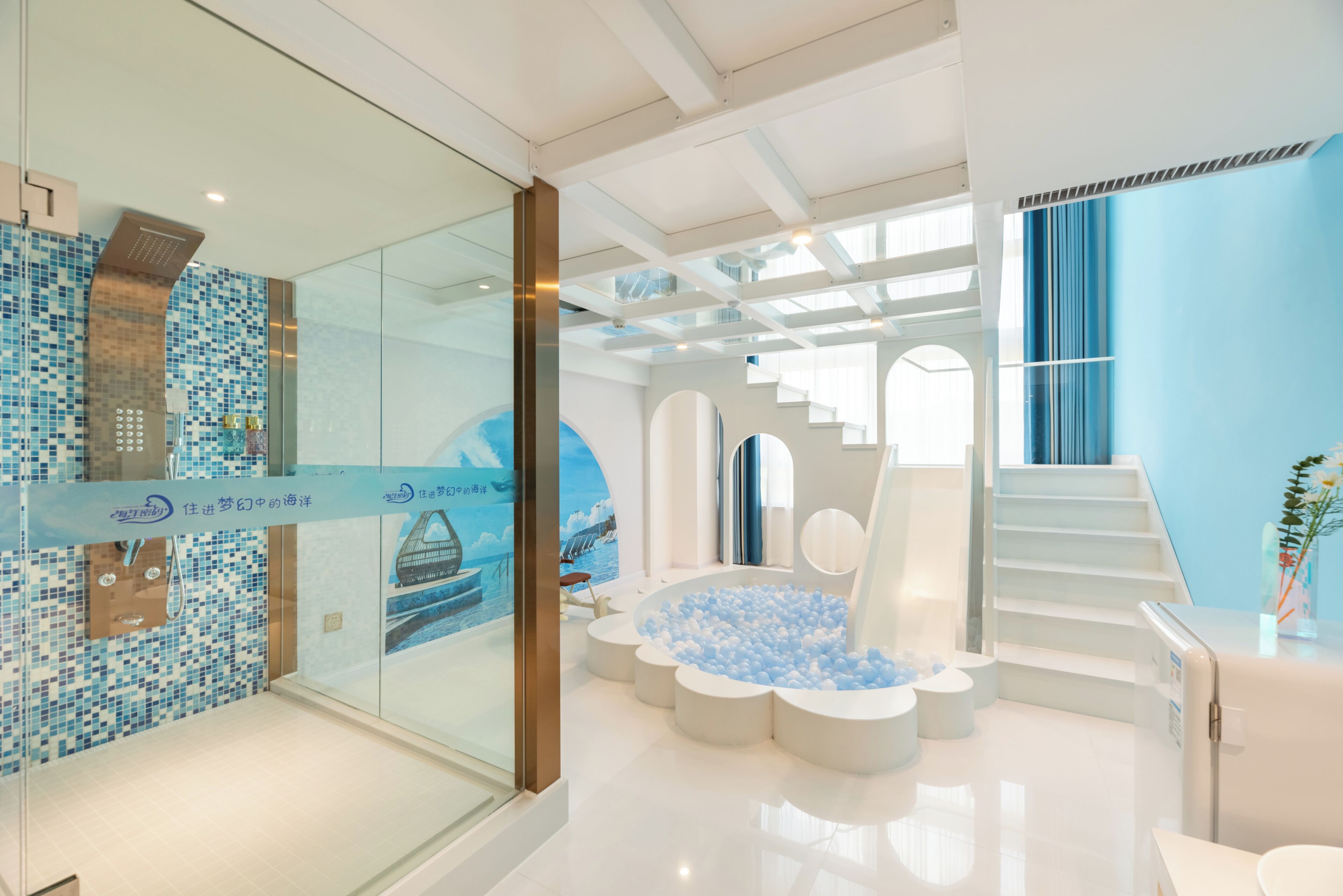 A modern bathroom with a glass shower enclosure, a blue mosaic wall, and a circular seating area with a blue and white color scheme.