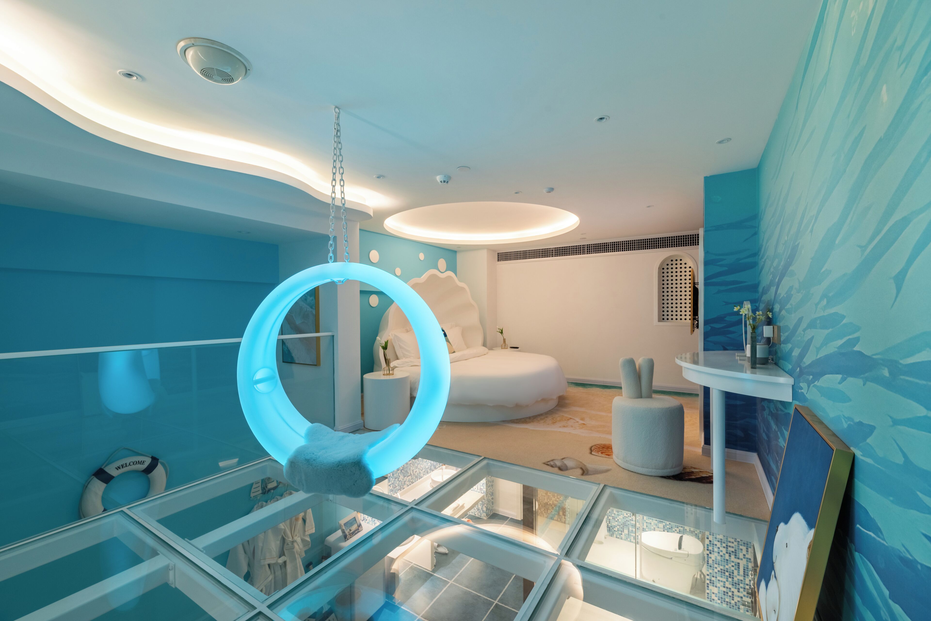 A modern bathroom with a glass-enclosed shower area, a white bathtub, and a circular mirror.