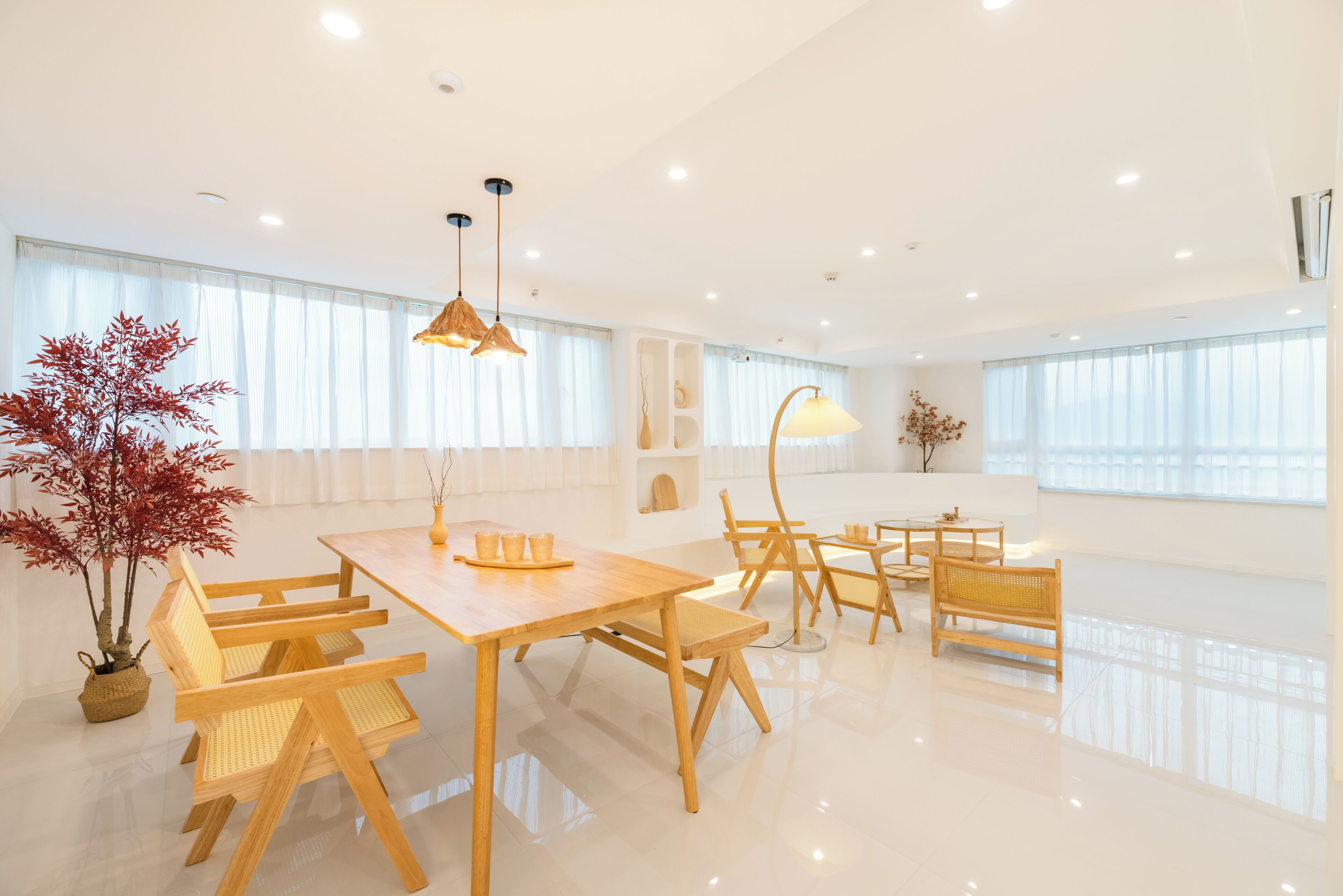 A modern, well-lit dining area with wooden furniture and large windows.