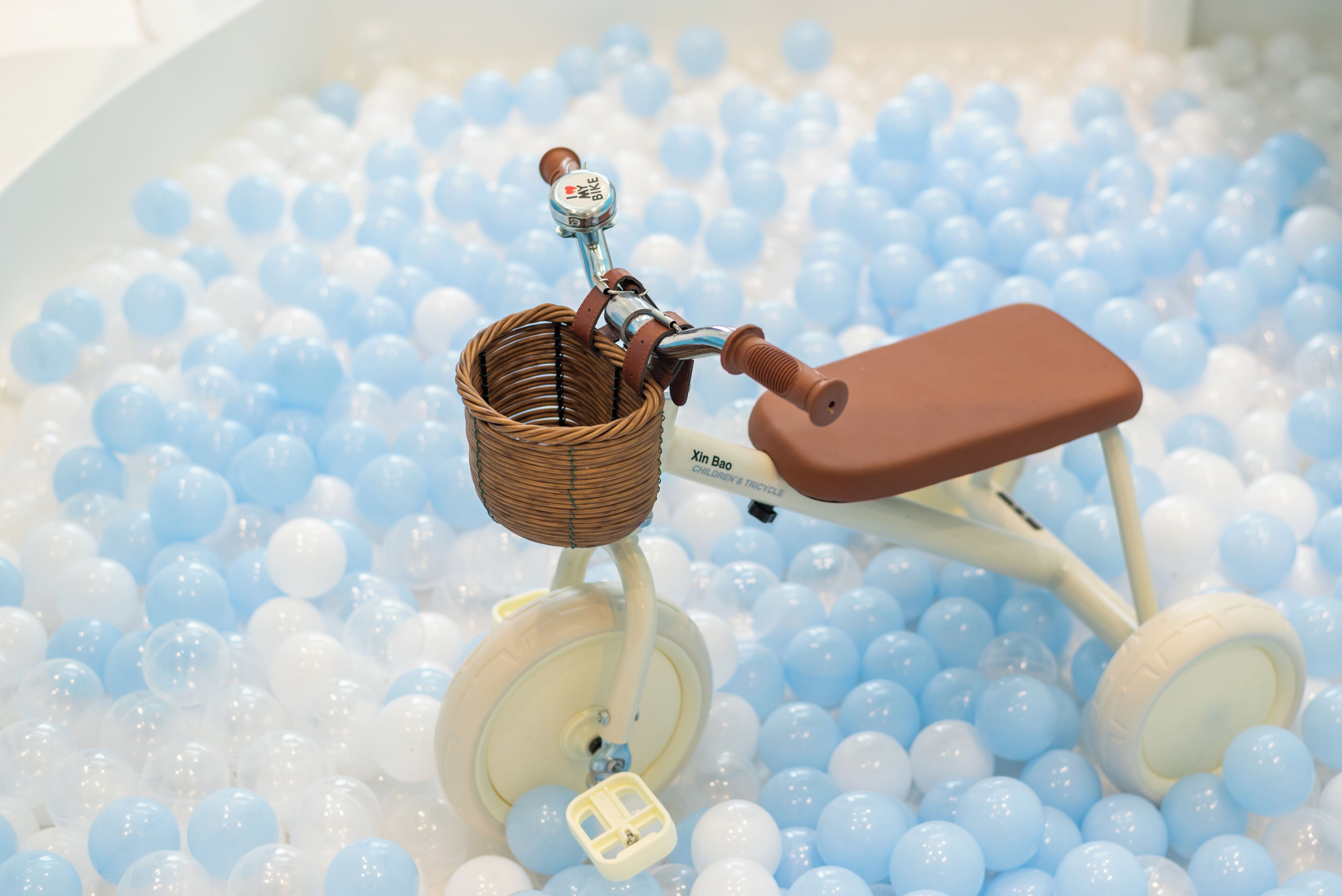 A toy bicycle in a ball pit.