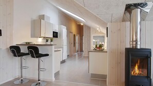 A modern kitchen with white cabinets, a central island, and two black bar stools.