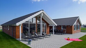 A two-story building with a covered patio area, large windows, and a brick exterior.