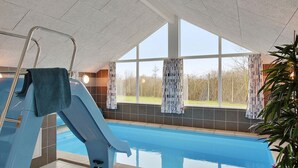 An indoor swimming pool with a slide, large windows, and a view of the outdoors. - VillaVilla 708 - Olpenitz, Deutschland (Kappeln)