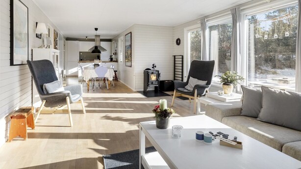 Un vaste espace de vie comprenant un canapé, des fauteuils, une table basse et une cheminée.