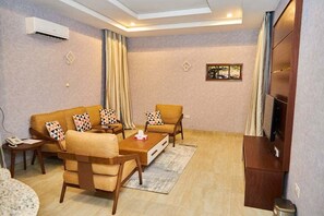 Apartamento família, sacada, vista para a cidade | Área de estar