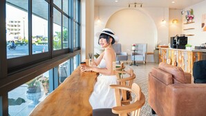 Een modern interieur met een houten bar, een zithoek en grote ramen met uitzicht op de straat.