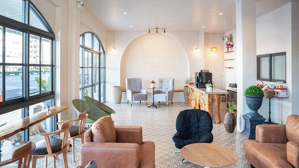 Een modern interieur met zitplaatsen, een koffiebar en grote ramen.