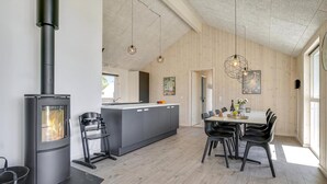 Una cucina moderna con isola centrale, piano cottura integrato e zona pranzo con tavolo e sedie.