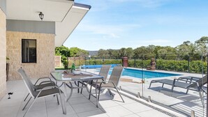 Une terrasse avec une piscine, des sièges d’extérieur et une statue de Bouddha.