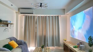 Una sala de estar moderna con sofá, mesa de centro y televisor.